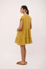 Vestido corto de lino color vino tinto, con escote en V y mangas cortas tipo musculosa. Presenta un corte holgado con volados en el ruedo.