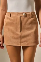 Minifalda de gamuza color camel, de corte recto, con talle alto y cierre frontal con un botón dorado.
