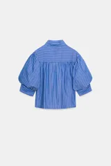 Camisa de cuello redondo con estampado de rayas verticales azules y blancas, manga larga abullonada y cierre frontal con botones.