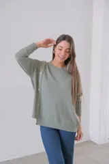 Sweater verde oliva de punto, corte recto y cuello redondo. Presenta detalle de botones en el hombro.