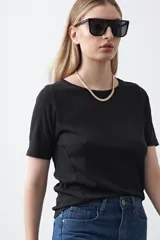 Remera de manga corta color beige claro, confeccionada en tejido acanalado elástico, con cuello redondo.