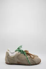 Zapatillas urbanas de cuero color beige con cordones intercambiables en verde y marrón.