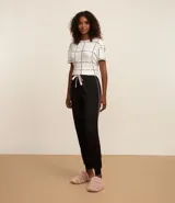Pantalón de pijama negro con cintura elástica, detalle de lazo rosa y ribete blanco en los laterales.