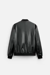 Cazadora bomber negra de efecto piel, corte relaxed fit, con cuello y puños de rib elástico, cierre frontal con cremallera, bolsillos laterales de doble vivo y bolsillo interior.