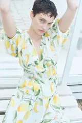 Blusa corta con escote en V pronunciado, elásticos finos en la cintura y peplum. Mangas globo cortas con elástico oculto en los puños. Estampado de limones y hojas verdes.