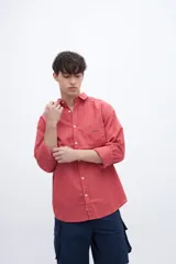 Camisa celeste de algodón, corte regular fit, con cuello solapa clásico, manga larga, bolsillo en el pecho y botones personalizados.