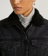 Campera de jean para mujer marca Blue Steel, color negro con lavado sutil. Cuenta con forro de felpa negro en el cuello y el interior, cuello camisero, manga larga, bolsillos delanteros con solapa y cierre frontal mediante botones metálicos.