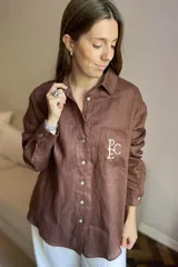 Camisa de lino color gris claro con bordado de monograma PEC en el bolsillo.