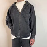 Campera con capucha de algodón color gris oscuro con efecto lavado y cierre frontal. Tiene bolsillos laterales y puños ajustados.