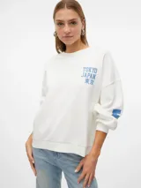 Sudadera blanca de cuello redondo, manga larga y corte oversize. Estampado frontal con la leyenda "Tokyo Japan 東京" en color azul. Diseño con puños y ruedo acanalados.