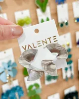 Aros colgantes plateados con forma de abanico plisado.
