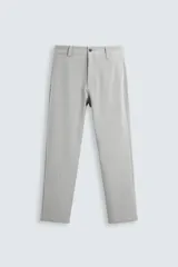 Pantalón de vestir gris claro, corte slim fit, con bolsillos laterales y traseros con botón. Cierre frontal con cremallera y botón.