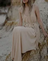 Vestido largo de color blanco, con escote en V pronunciado y tiras largas que permiten anudarlo de múltiples formas. Presenta tajo en ambos laterales y forro interno.