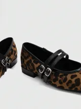 Balerinas color borgoña con puntera cuadrada y tira cruzada con hebilla y ojales metálicos.