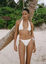 Top de bikini blanco con diseño triangular, anilla decorativa en el centro, cierre de lazo en cuello y espalda, y forro interior.