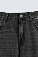 Pantalón de jean celeste de corte flare, con tiro medio, cinco bolsillos, cierre frontal con cremallera y botón, y bajo con acabado irregular.