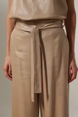 Pantalón ancho de tiro alto color beige metalizado, confeccionado en lino y viscosa, con lazo para ajustar en la cintura.