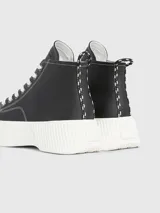 Zapatillas de caña alta Tommy Jeans, color negro, con cordones blancos y suela de plataforma blanca.