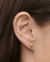 Aros pequeños dorados con forma de esfera.