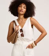 Musculosa sin mangas color blanco, confeccionada en viscosa sostenible, con escote en pico y corte vertical.