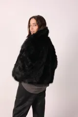 Campera de piel sintética color beige, de corte recto y mangas largas.
