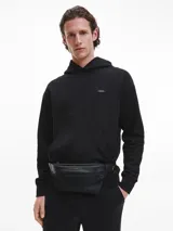 Buzo negro con capucha y bolsillo tipo canguro. Logo de Calvin Klein bordado en el pecho.