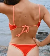 Top de bikini color naranja con contorno y tirantes en rojo.