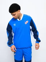 Buzo deportivo azul marino, rojo y blanco con escudo del Club Nacional de Football en el pecho y logo de Umbro en la manga.