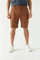 Bermuda de hombre color marrón con estampado de lunares pequeños, corte chino, con pasacintos, cierre frontal y logo metálico pequeño en la parte trasera.