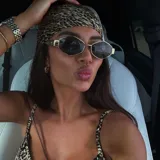 Lentes de sol hexagonales con marco dorado y lentes marrones y negros.