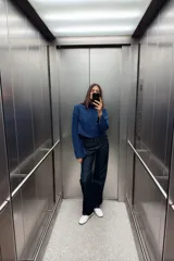 Sweater azul de tejido de punto grueso, con cuello alto y mangas largas acampanadas.
