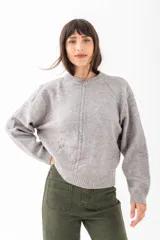 Sweater de punto color crudo, con cuello redondo y detalle de trenza vertical en el centro.