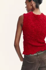Top rojo de punto con textura, cuello redondo y sin mangas.