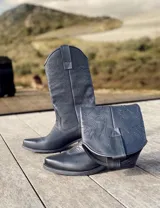 Botas de cuero negro con bordado decorativo en el caño y empeine, taco bajo y punta fina. Diseño de estilo cowboy.