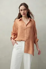 Camisa estampada con figuras geométricas en tonos azul, marrón y beige. Corte relajado, manga tres cuartos y botones al frente.