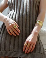 Brazalete rígido plateado con textura irregular.