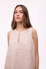 Vestido corto sin mangas de color rojo, con cuello redondo y detalle de abertura tipo gota en el pecho. Presenta un diseño holgado y terminación con volado en el ruedo.