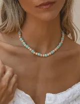 Collar corto con cuentas redondas color beige alternadas con cuentas cuadradas color celeste.