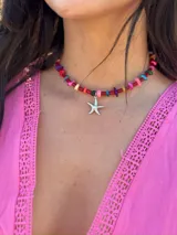 Gargantilla de cuentas blancas con dije de estrella de mar dorada.