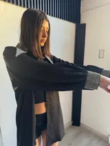 Camisa negra de manga larga con cuello clásico y puños con apliques de strass.