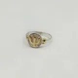 Anillo dorado con dije redondo con el símbolo de psicología en color plateado.