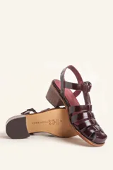 Sandalias de cuero color borgoña con tiras entrecruzadas, hebilla lateral y taco de madera.