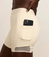 Bermuda deportiva color crema, confeccionada en microfibra pesada, con cintura elástica con lettering GYM texturizado y bolsillos laterales.