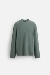 Jersey verde de punto con cuello redondo y manga larga.