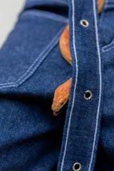 Pantalón de jean azul de tiro alto, corte ancho y denim rígido. Incluye cinturón y tiras desmontables.