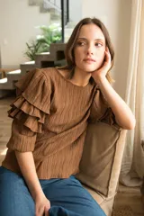 Blusa color marrón con spandex, mangas 3/4 con tres volados y puño elástico. Cierre con botón en la espalda.