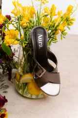 Sandalia tipo zueco de charol rojo con hebilla dorada y taco cuadrado.