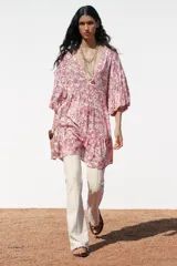 Vestido corto con estampado floral en tonos rosados, escote en pico y mangas abullonadas.