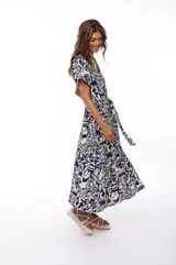 Vestido midi con estampado floral en tonos azul marino y blanco, escote en V, mangas cortas y falda acampanada con cinturón ajustable.