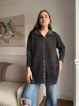 Camisa de tejido calado color negro con brillo, de corte holgado y mangas largas.